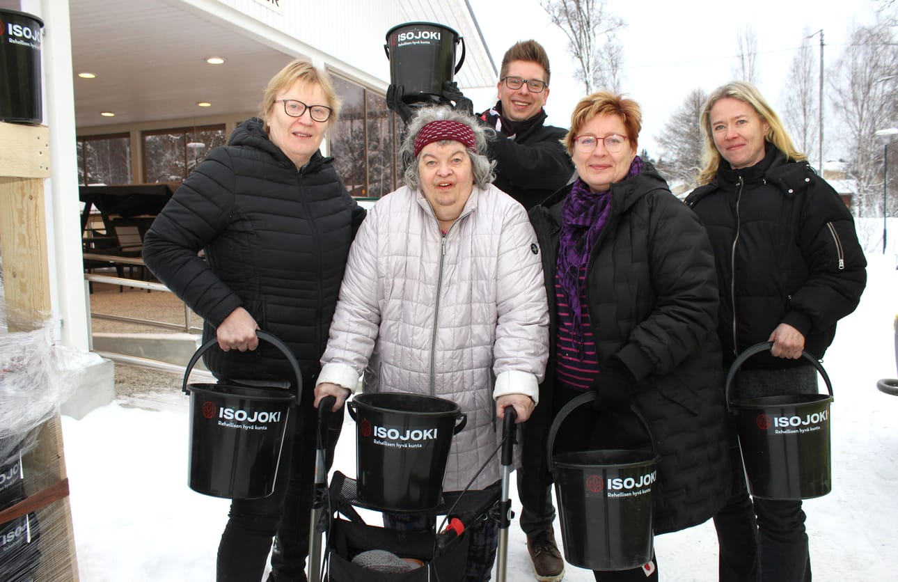 Villa Walterin asukas Martta Välineva sai joululahjaämpärin viime perjantaina. Kuvassa vasemmalla kotihoidon työntekijä Meri Karikoski ja Välikosken oikealla puolella Anja-Riitta Forsman sekä kunnanhallituksen puheenjohtaja Pia Jaakkola. Takana kunnanjohtaja Juha Herrala.