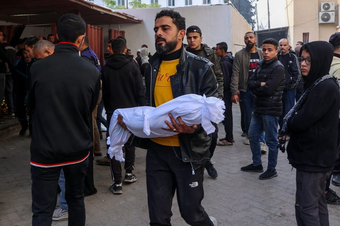 Mies kantoi Israelin iskussa kuolleen pienen lapsen ruumista torstaina Gazan kaupungissa. LEHTIKUVA/AFP