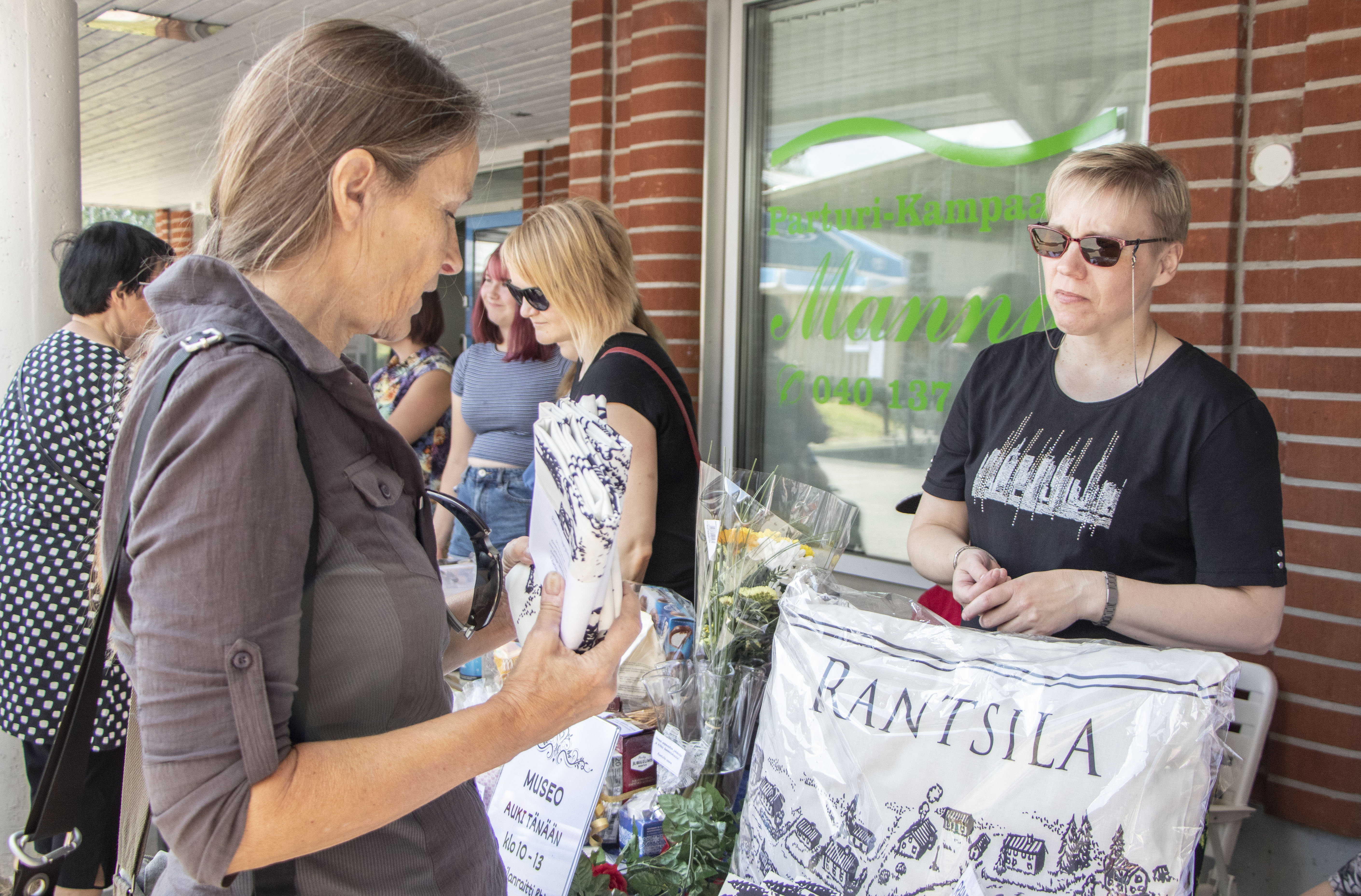 Marja Nousiainen osti Rantsila-seuran pöydästä Eija Tuomaalalta kotiin viemiseksi Kaliforniaan Rantsila-tyynyliinan.