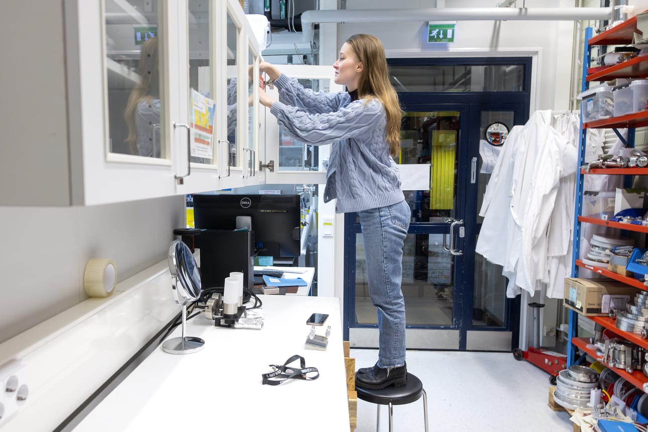 Veera Tapionkaski näyttää, miten aurinkovedyn valmistus toimii. Tarvittava välineistö löytyy Oulun yliopiston Nanomo-laboratorion kaapeista.