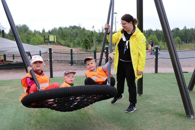 Lastenhoitaja Hanne Hautakangas antoi vauhtia Olivia Salolle, Liam Kujalalle ja Eemi Sivulalle Mäntymäen päiväkodin pihalla.