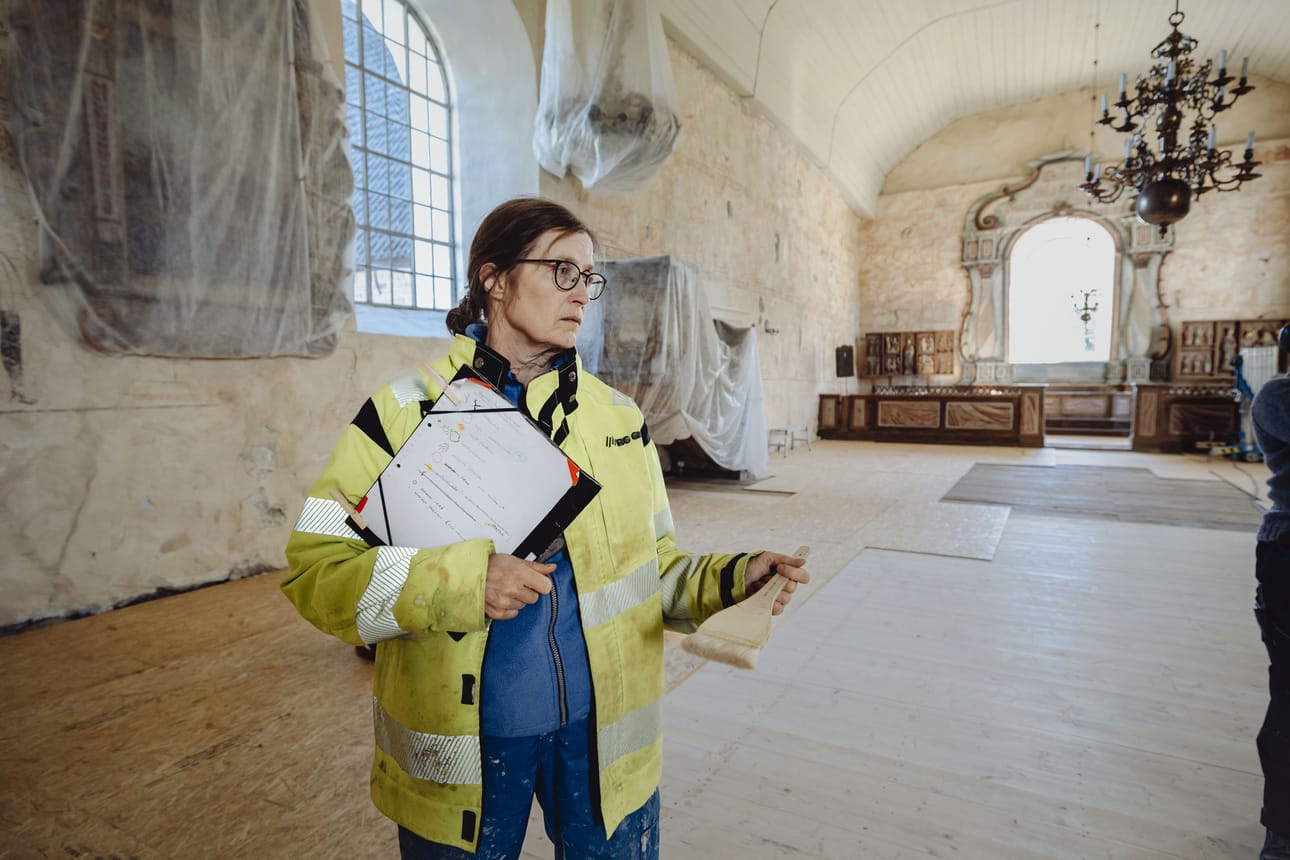 Konservaattori Kaija Niiranen viimeistelee Isonkyrön keskiaikaisen, kulttuurihistoriallisesti arvokkaan kirkon seinäpintoja. Niille on pöllähtänyt pölyä vanhojen lattialankkujen avauksen yhteydessä.