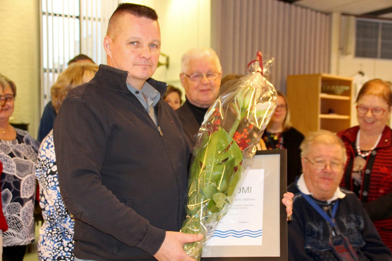 Hannu Mällinen palkittiin esteettömyyden edistämisestä ja hyvästä palvelusta. Taustalla kunniakirjan myöntäneen Ruukiin Invalidit ry:n edustajia.