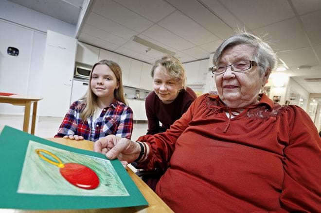 Joulukortit yhdistivät sukupolvia, kun Neea Pääkkönen ja Kasper Hyytiäinen antoivat itse tehdyn kortin Simunanrannan palvelukeskuksessa joulua odottavalle Alli Kukolle. KUVAT: KARI LÖFHJELM
