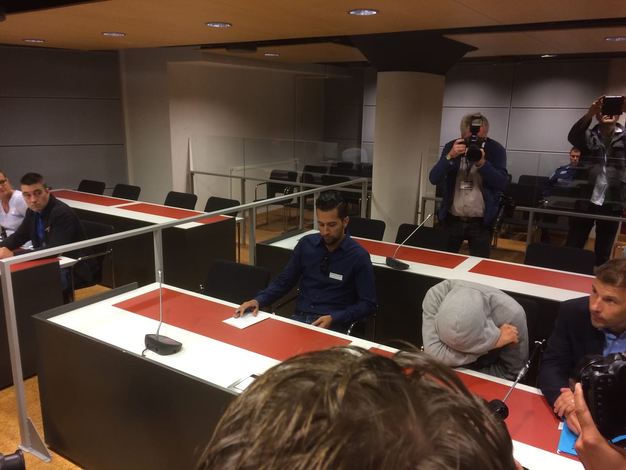 Harmaaseen huppariin pukeutunut Mohamed Bakier peitti kasvonsa, kun tiedotusvälineet olivat käräjäsalissa.