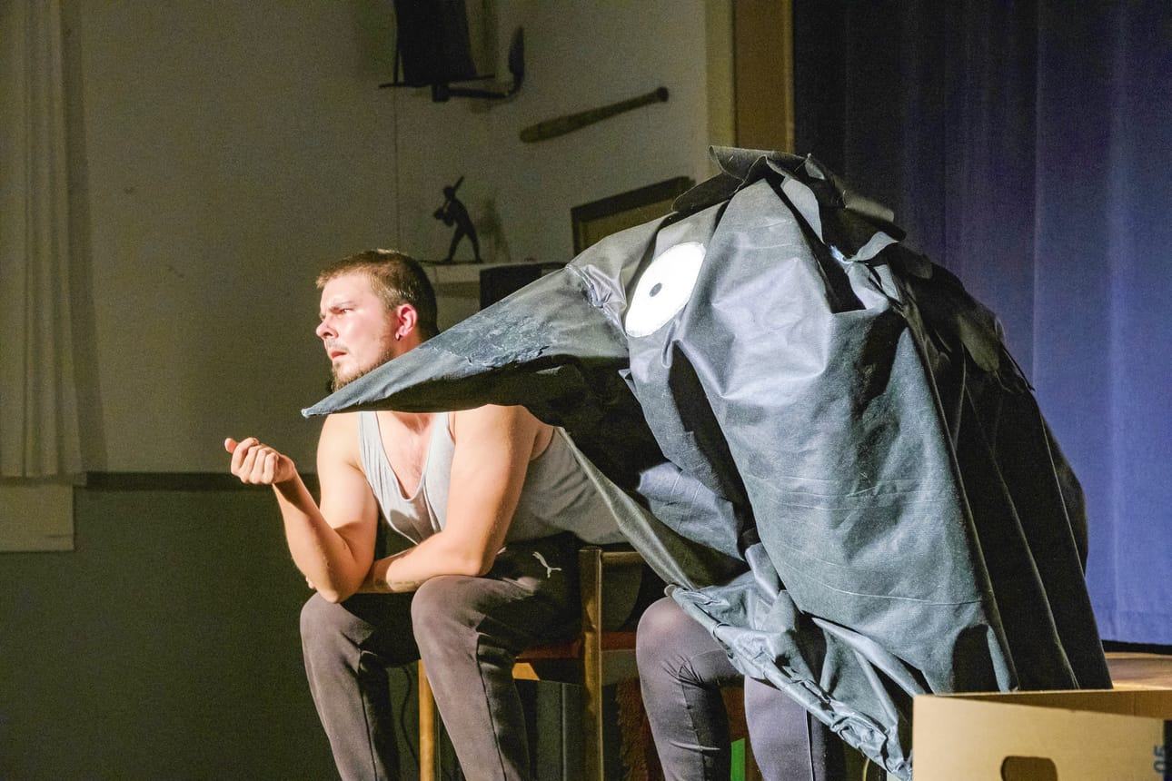 Mies ja Naakka. Teatteri Sidoksen tulkinnassa Naakka on miehen (Juho Ljokkoi) harhanäky. Naakkana esiintyvän Epe Niirasen sympaattisen näköisen naakkapuvun toteutti Anni Majava.