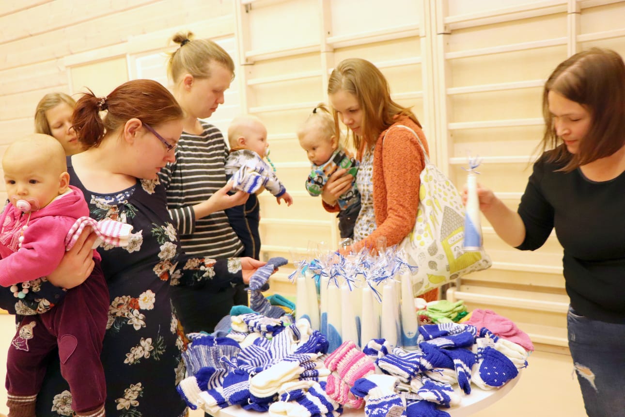 Äidit valitsemassa sopivia sukkia vauvoilleen. Suomi 100 -juhlavuonna neulottuja sinivalkoisia villaisia on vielä jäljellä.