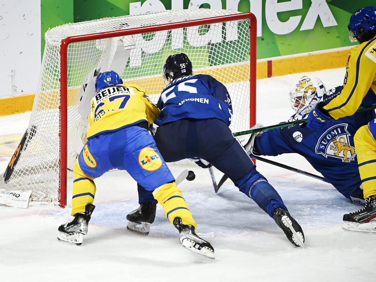 Suomen maalivahti Jussi Olkinuora ja puolustaja Atte Ohtamaa kurottavat liian myöhään kiekon perään. Ruotsi karkaa 2-0 johtoon.