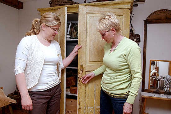 Vanhoista huonekaluista pitävät Marja Sova (vas.) ja Riitta Heikkala tutkivat Sovan kotona olevaa 1800-luvun kaappia.