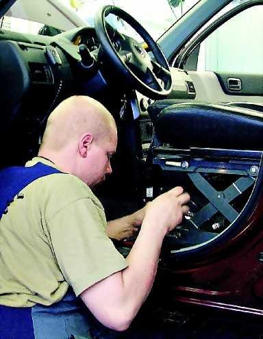Pyörätuoli katolle. Myyntiedustaja Markku Laulumaan invalidiautossa pyörätuoli nousee robotin avulla auton katolle.
