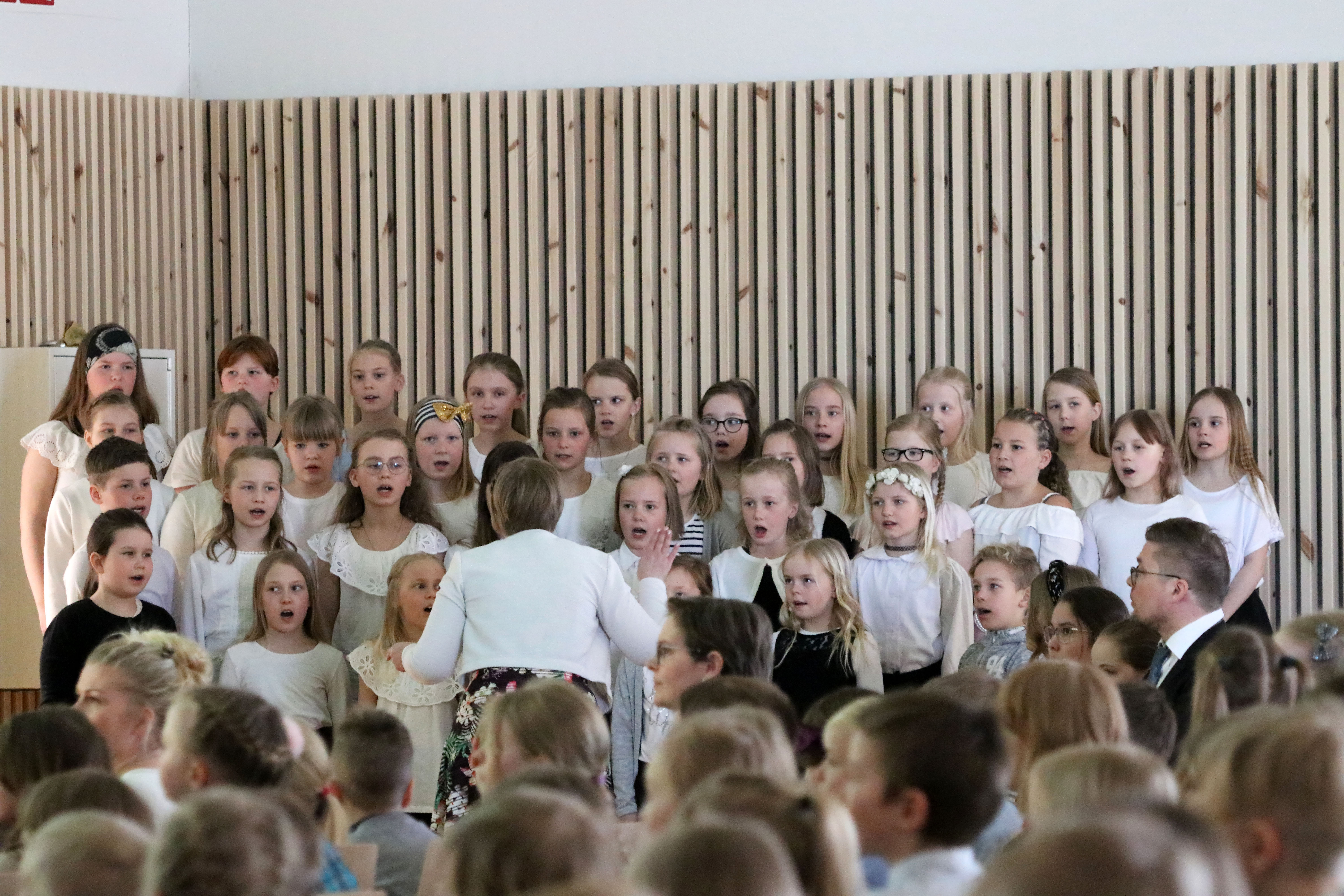 Musiikki oli yksi Ojanperän koulun vihkiäisten pääelementeistä. Kuoroa johtamassa Suvi Seppälä.