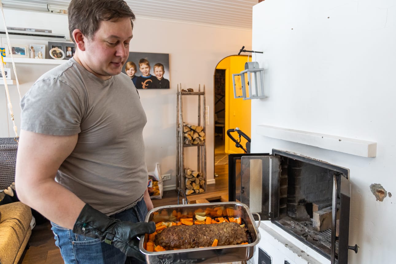 Esko-Juhani Kuisti nostaa takasta vuoan, jossa on rotukarjan lihasta valmistettua mureketta sekä kylkiäisenä porkkanaa ja sipulia. Paistoaika oli noin puolitoista tuntia ja uunissa paloi ennen valmistusta kaksi täyttä pesällistä puita.