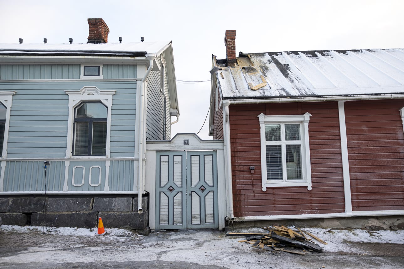 Sunnuntain tulipalosta muistuttavat osittain purettu tummunut savupiipunvierus sekä lautakasa kadulla.