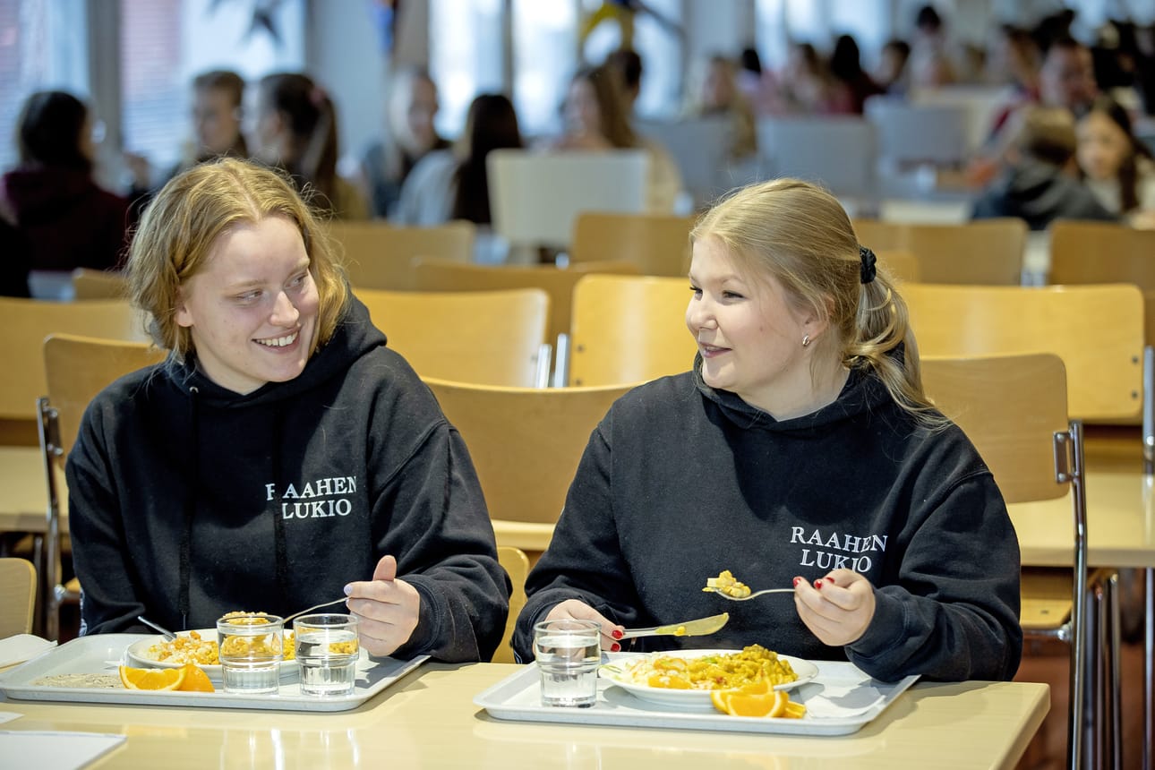 Ronja Valkonen ja Krista Kyröläinen ruokailivat Raahen lukiolla perjantaina. Ruokana oli broileri-pastavuokaa.