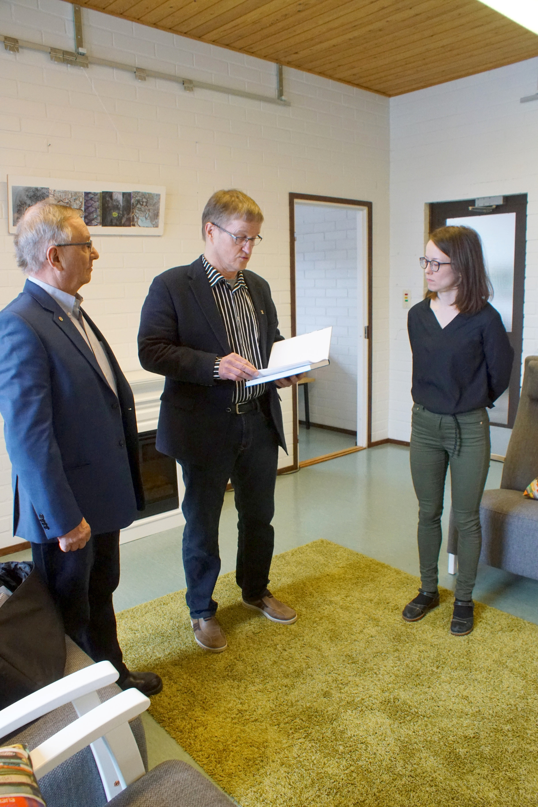 Paavo Ervasti ja Vesa Holmström luovuttivat kirjan kirjastonjohtaja Outi Nivakoskelle ja lainaajien käyttöön.