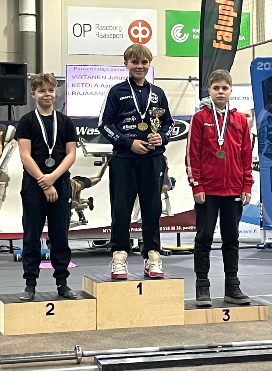 Julius Virtanen nousi Tammisaaressa kultamitalikorokkeelle. Vasemmalla hopeaa saanut Aarni Ketola ja toisella puolella pronssille yltänyt Viljami Rajakangas.