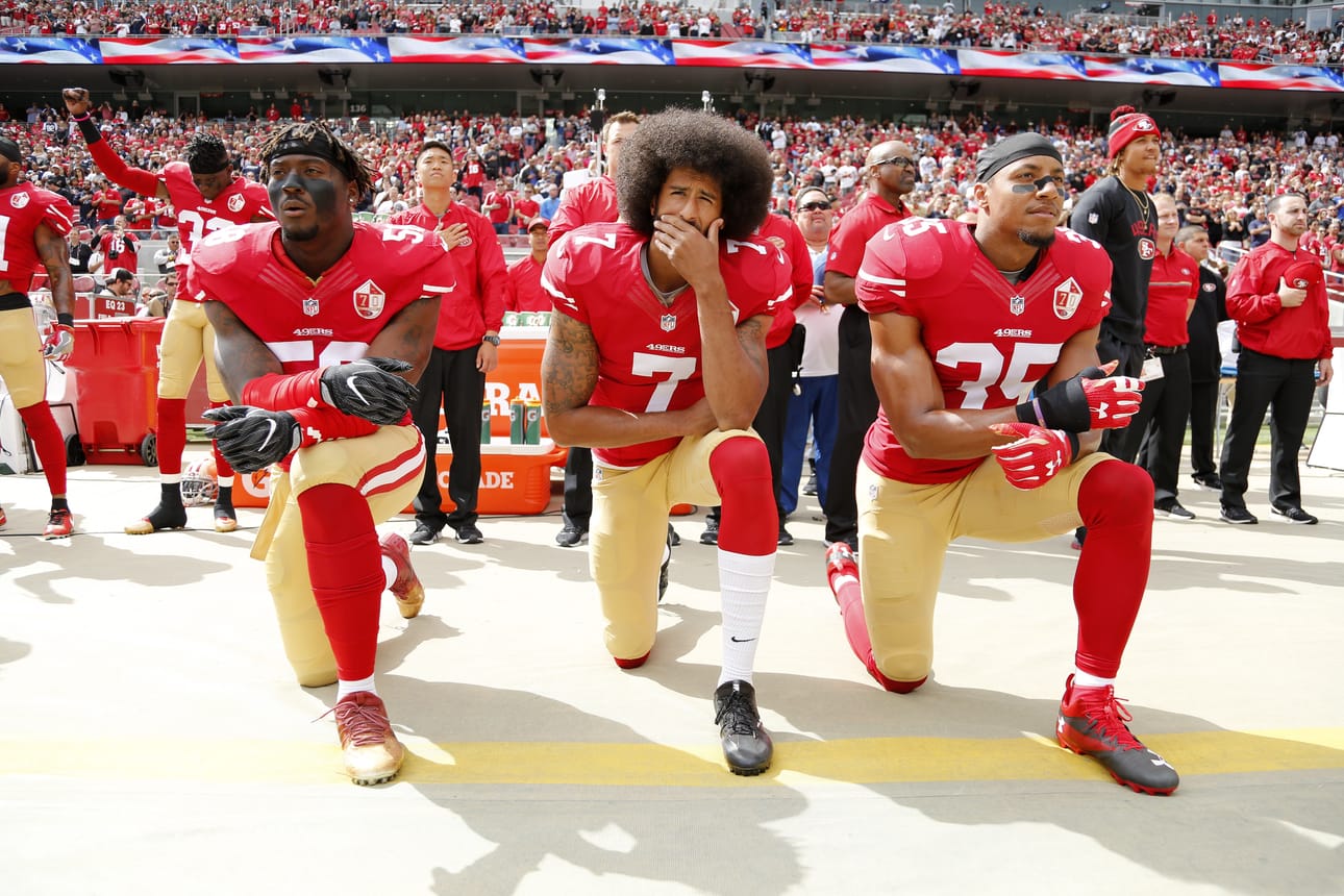 Kuvassa keskellä urheilijoiden polvistumisprotestin aloittanut Colin Kaepernick.