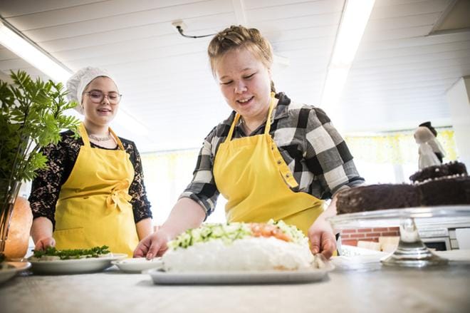 Ysiluokkalaisten hääjuhlien emäntänä toimi Vilma Niemelä (oik.), ja hän muun muassa johti puhetta, kun päätettiin, mitä hääjuhlissa tarjotaan. Kattausta oli viimeistelemässä myös Sanni Lampela. KUVA: Jussi Leinonen