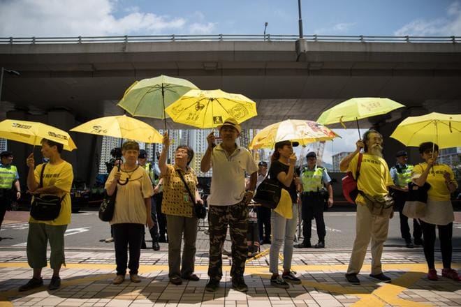 Sadat Occupy Central -johtajien kannattajat osoittivat mieltään oikeustalon edustalla keltaiseen pukeutuneina. KUVA: JEROME FAVRE