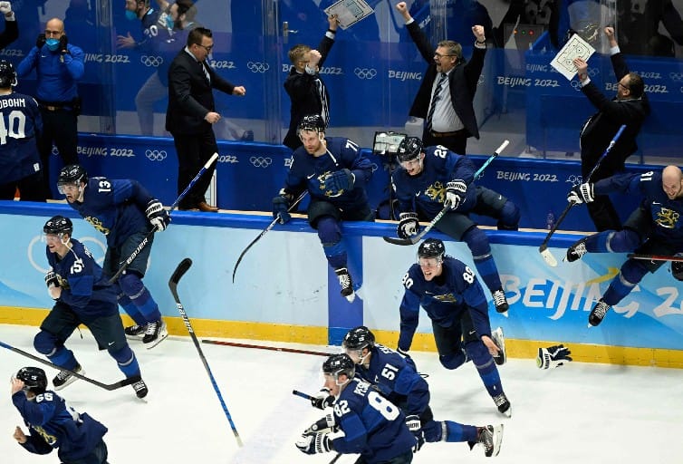 Leijonien vaasalainen apuvalmentaja Mikko Manner tuulettaa kuvassa takana keskellä olympiavoiton varmistuttua. Päävalmentaja Jukka Jalonen (toinen oik. takarivissä) päästi myös riemun valloilleen.