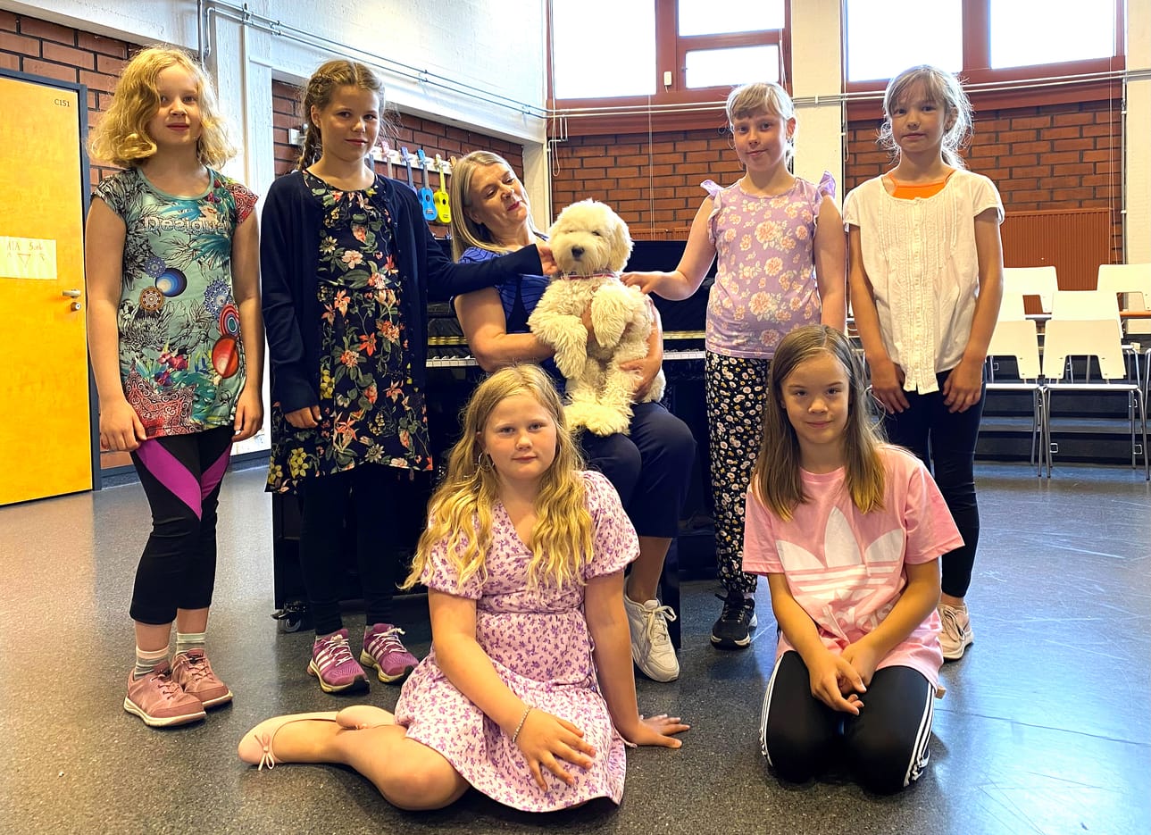 Hyllykallion koulun 4C-luokan laulavia tyttöjä Pirjo Kotkaniemen ja Armin ympärillä (ylävas.) Olivia Rajalampi, Venla Ala-Luoma, Ella Yliselä ja Mila Klasila, alarivissä Linnea Yli-Kokkila ja Emmi Hankaniemi.