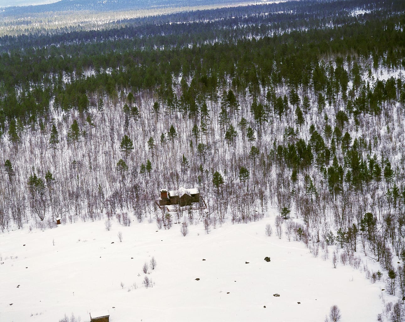 Pielpajärven erämaakirkko sijaitsee metsän reunassa. Edessä avautuu kirkkokenttä, joka oli aikoinaan täynnä kirkkotupia. Ilmakuva vuodelta 1999.