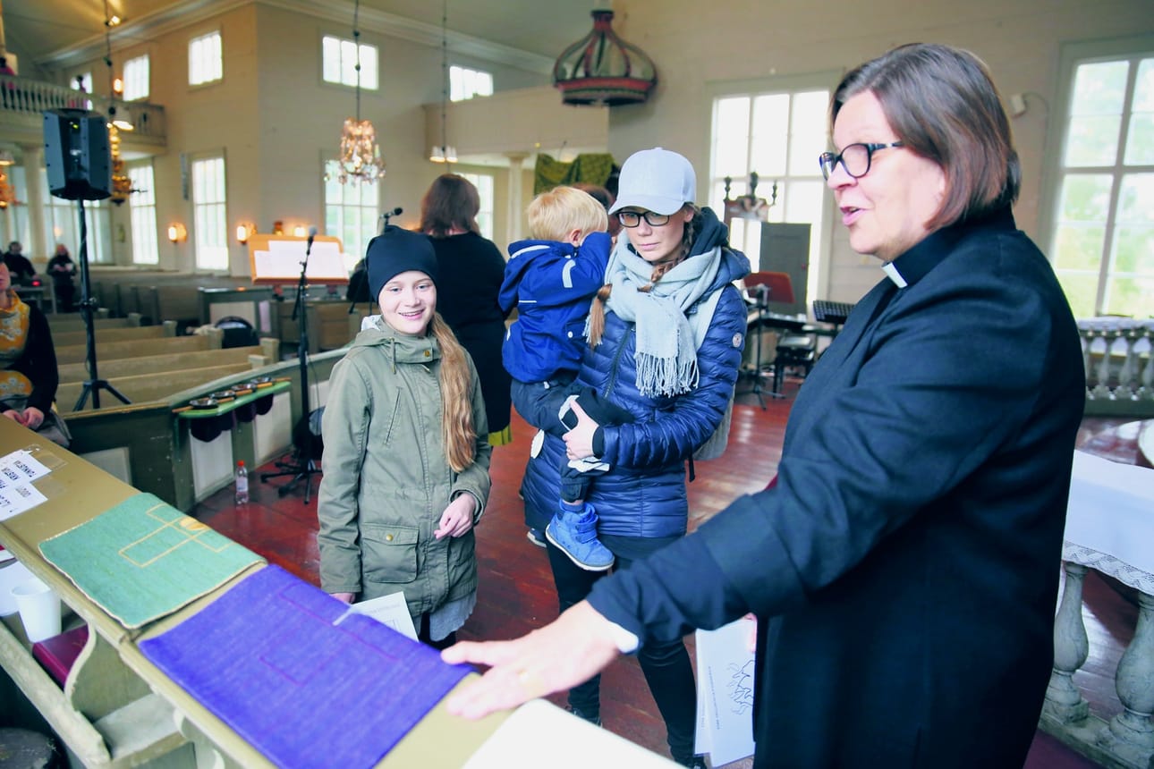 Maisa Hautamäki kertoi Eveliina, Jenni ja Kaarle Kujalalle jumalanpalveluksissa käytettävistä väreistä ja niiden merkityksistä.