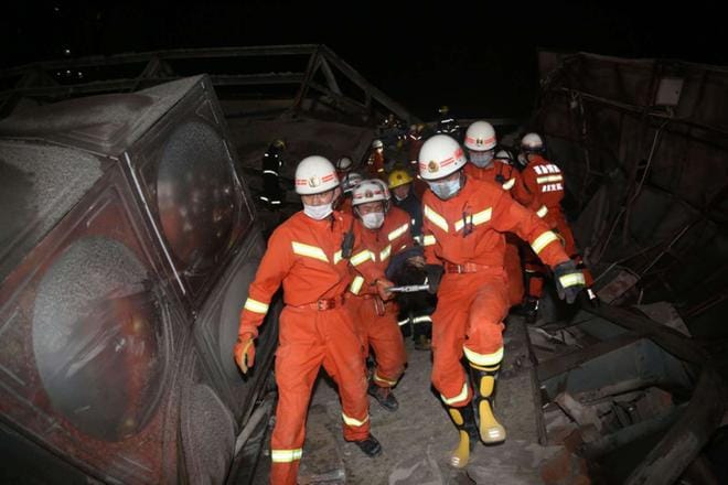 Pelastustyöntekijät kuljettavat hotellin romahduksessa loukkaantuneita ihmisiä Kiinan Quanzhoussa. KUVA: EPA
