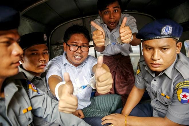 Reutersin toimittajat Wa Lone (kesk.) ja Kyaw Soe Oo näyttivät kuvaajille yläpeukkua maanantaina poistuessaan Yangonin oikeustaloilta sen jälkeen, kun heille oli luettu vankeustuomio. KUVA: LYNN BO BO/EPA
