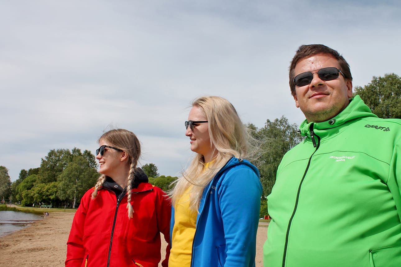 Hanna Konttijärvi (vas.), Anna Karjalainen ja Pekka Hurskainen seuraavat, montako päätä vedenpinnan yläpuolella näkyy. Työ kutsuu uimavalvojia myös sateisina päivinä, jolloin he vahtivat sinnikkäitä uimareita joko sisältä tai katoksen alta.