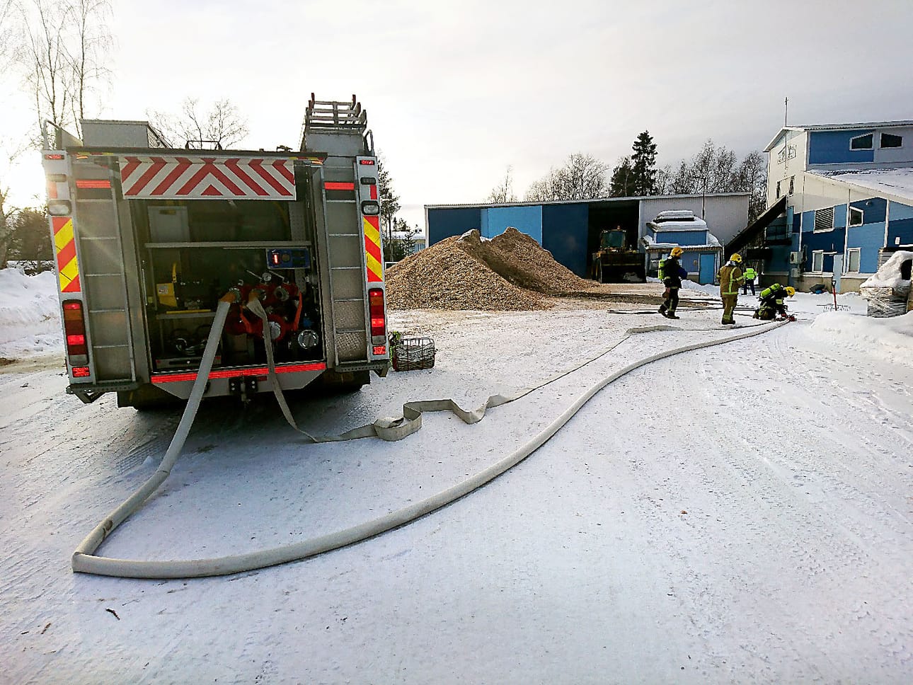 Pelastajat sammuttivat hakekasan palon vedellä ja pöyhimällä kasaa pyöräkoneella.