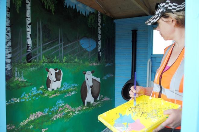 Satu Kaunisto sai Lasikodan vessaan maalaamansa maalaismaiseman valmiiksi torstaina. KUVA: EEVA-LIISA KULJU