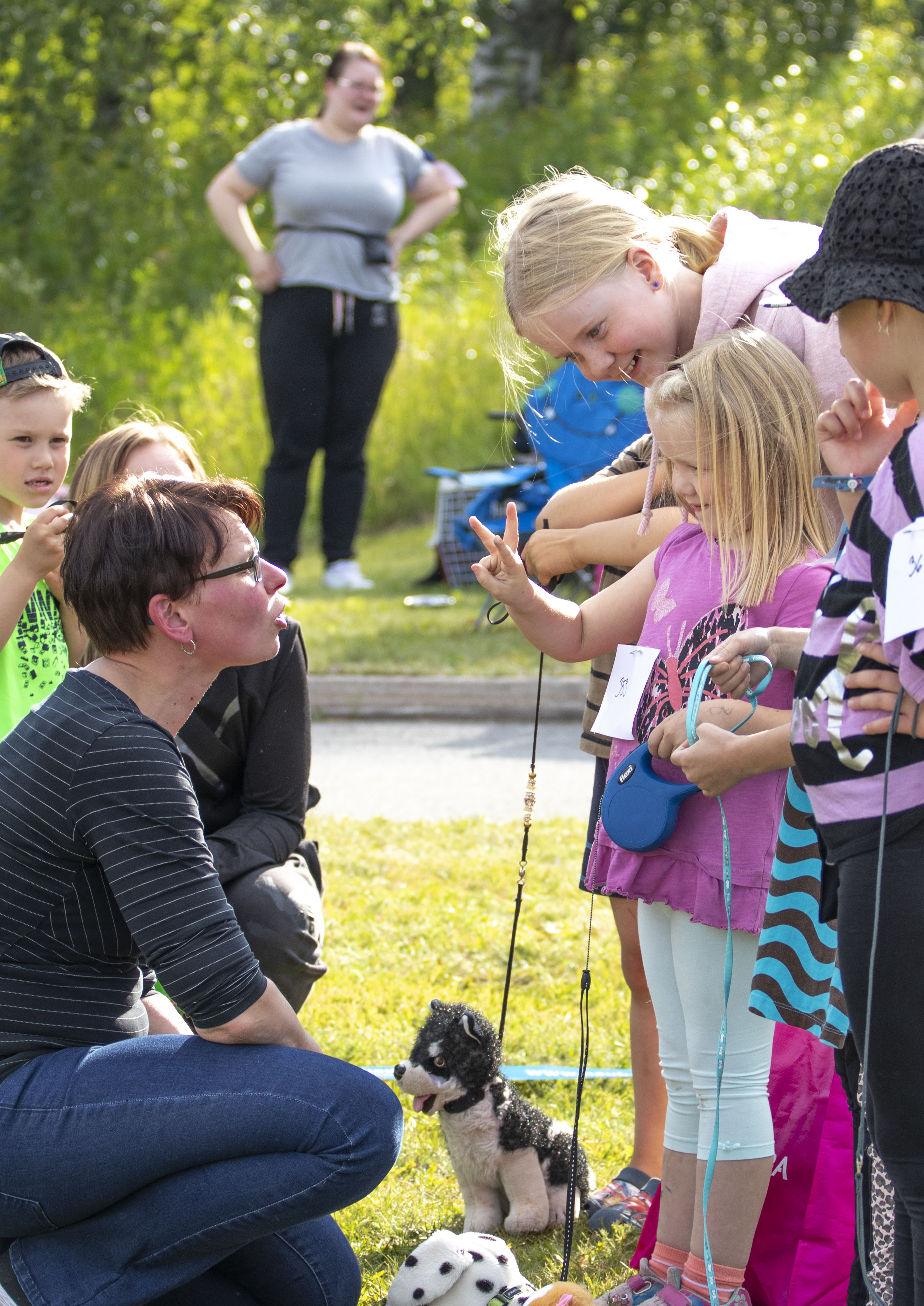Lapsi ja koira sekä lapsi ja leulukoira kehää tuomaroineella Hanna Tolosella oli haastava tehtävä. 5-vuotias Janna Sovisalo näyttää, kuinka vanha Täplä-koira on. Apuna näyttelytilanteessa oli isosisko Noora Viio.
