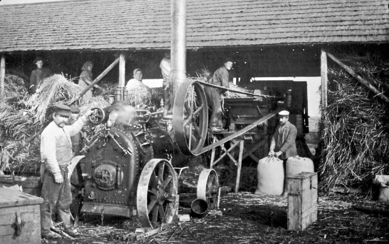 Viljanpuintia Orava-Toppisella 1922. Voimakoneena on höyryllä toimiva Lokomo. Vasemmalta koneenkäyttäjä Matti Pekkala, säkittäjä Juho Orava-Toppinen ja ryskyyn syöttäjä Santeri Hartikka. Kuva Toivo Laatikaisen kokoamasta Tyrnävän kotiseutu- ja museoyhdistyksen kuva-arkistosta.