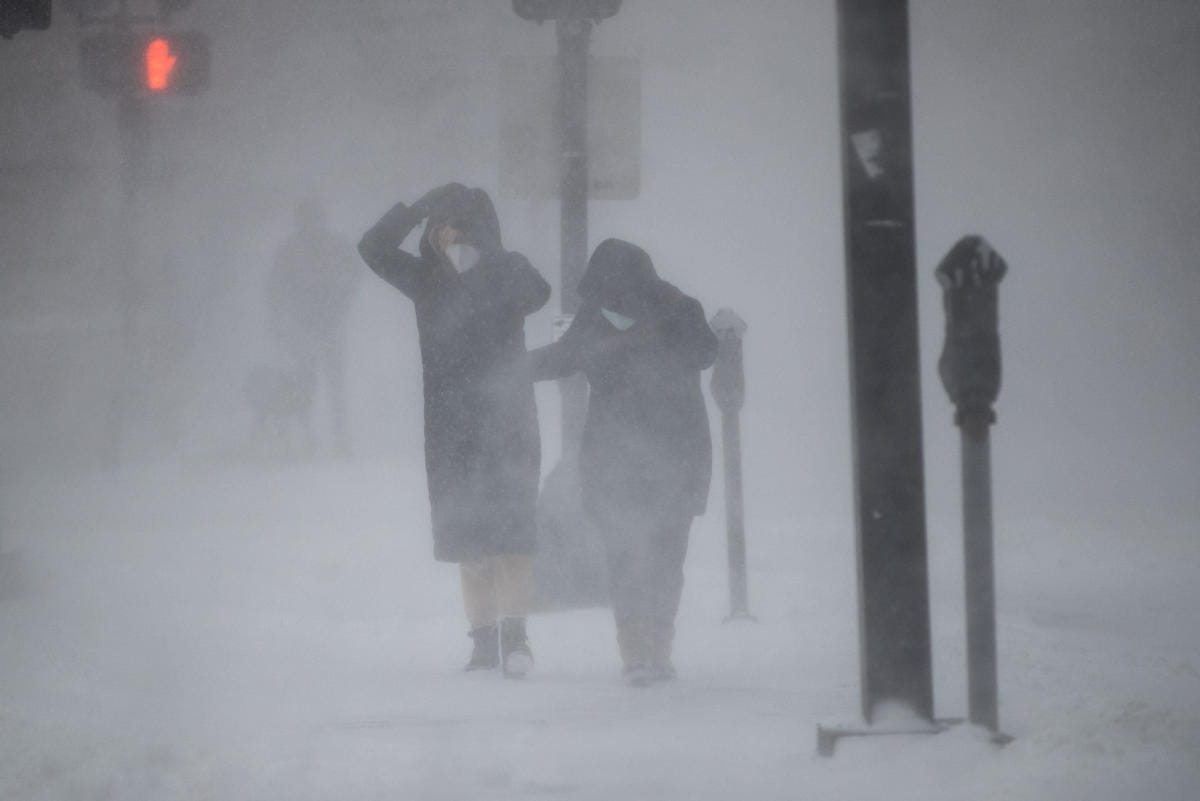 Ihmiset kamppailivat lauantaina Bostonin kaduilla tuulessa ja tuiverruksessa. LEHTIKUVA /AFP