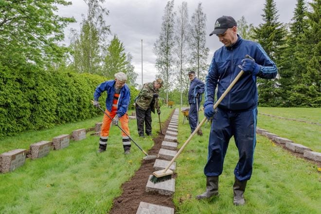 Sankarihautausmaan kunnostustalkoita johti seurakuntamestari Juha Akonniemi (oik.). Mukana talkoissa olivat muun muassa Pekka Päivärinta (vas.), Jorma Turpela ja Rauno Keskitalo. KUVA: AARRE LÖYTÖMÄKI