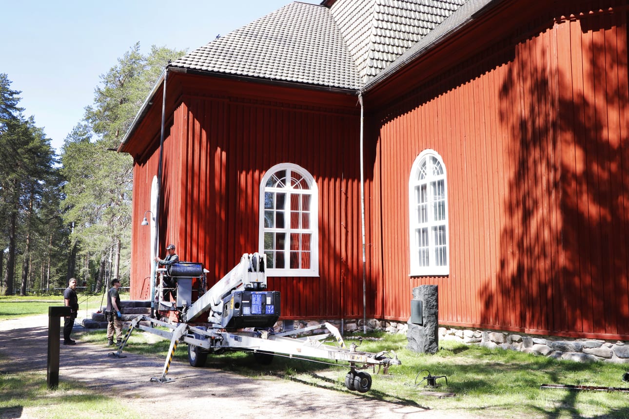 Esko Puhto työmiehineen aloitteli kirkon katon tervausta tiistaina.