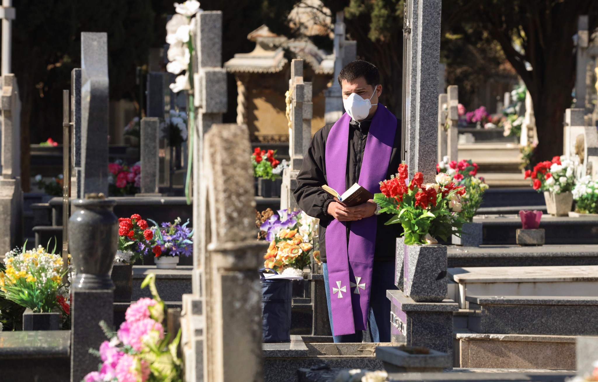epa08340873 A priest prays during a burial without relatives or friends at the Cemetery of Salamanca, northern Spain, 03 April 2020. Government banned wakes and only three people can attend burials as part of the measures taken to avoid the spreading of coronavirus outbreak. Spain faces the 20th consecutive day of mandatory home confinement in a bid to slow down the spread of the pandemic COVID-19 disease caused by the SARS-CoV-2 coronavirus.  EPA/JM GARCIA, BY: ALL OVER PRESS / EPA-PHOTO CODE: EPAXX8
