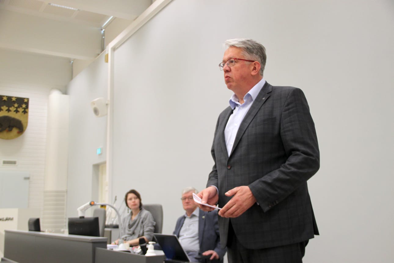 Juha Rehula vakuutti, että Suomessa asuu maailman onnellisin kansa. Takana tilaisuuden puheenjohtaja Jorma Kouva ja Mirka Pääkkö.