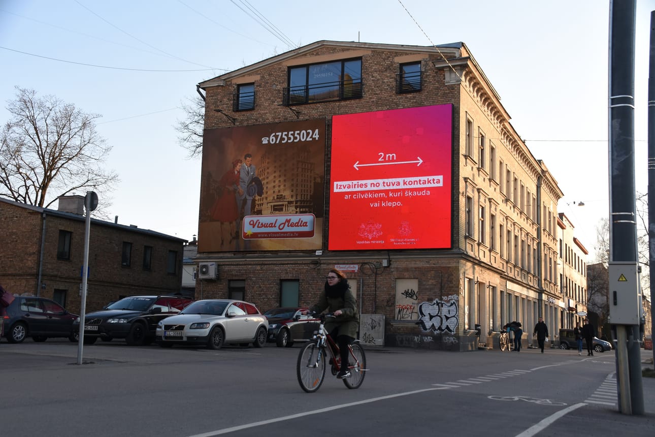 Pääkaupunki Riian kaduilla on kaikkialla ilmoituksia, joissa kehotetaan pitämään kahden metrin etäisyys muihin ihmisiin.