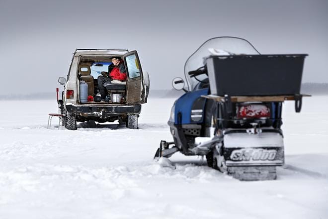 Kylmästä lämpimään. Vimpeliläisen Rauno Toivolan ei tarvitse ajella moottorikelkalla jäälakeudella ja pilkkiä sään armoilla. Mies narraa kalaa autonsa sisältä. KUVAT: TOMI KOSONEN