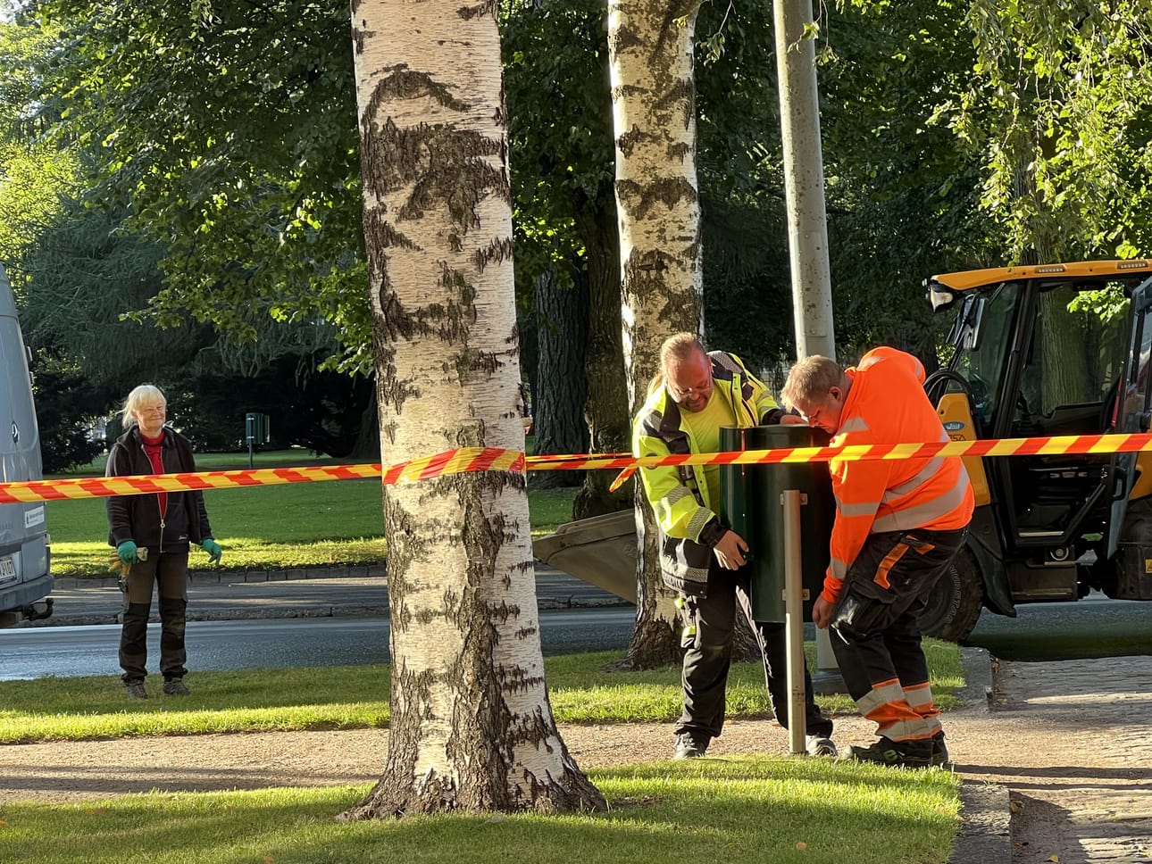Kaksi kaupungin työntekijää poistaa roskakorin Hovioikeudenpuistikolta kruununprinsessan vierailun ajaksi.