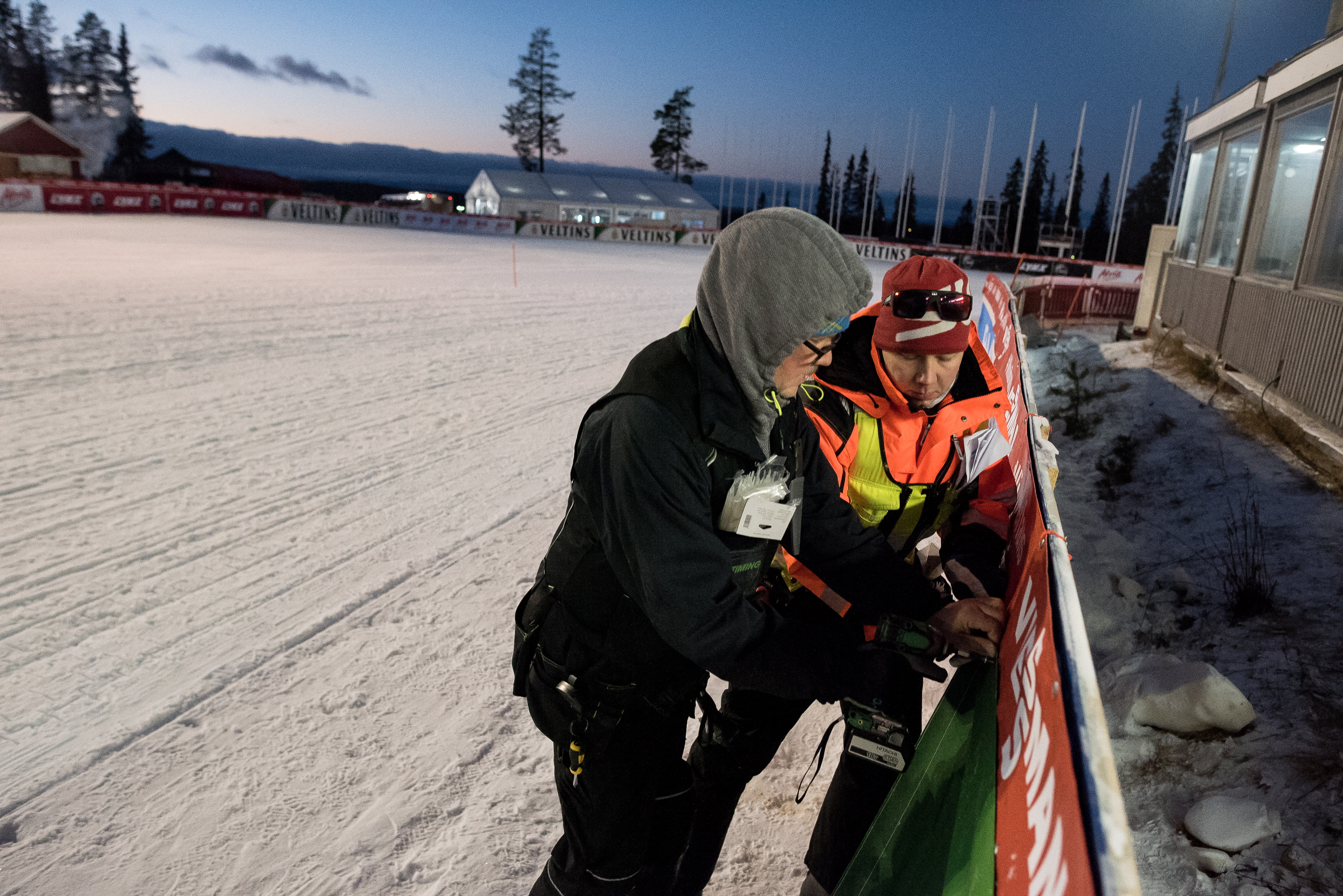 Jyri Immonen ( edessä ) ja Timo Reijonen asettivat yhdistetyn ja maastohiihdon mainoksia paikoilleen torstaina hiihtostadionilla.