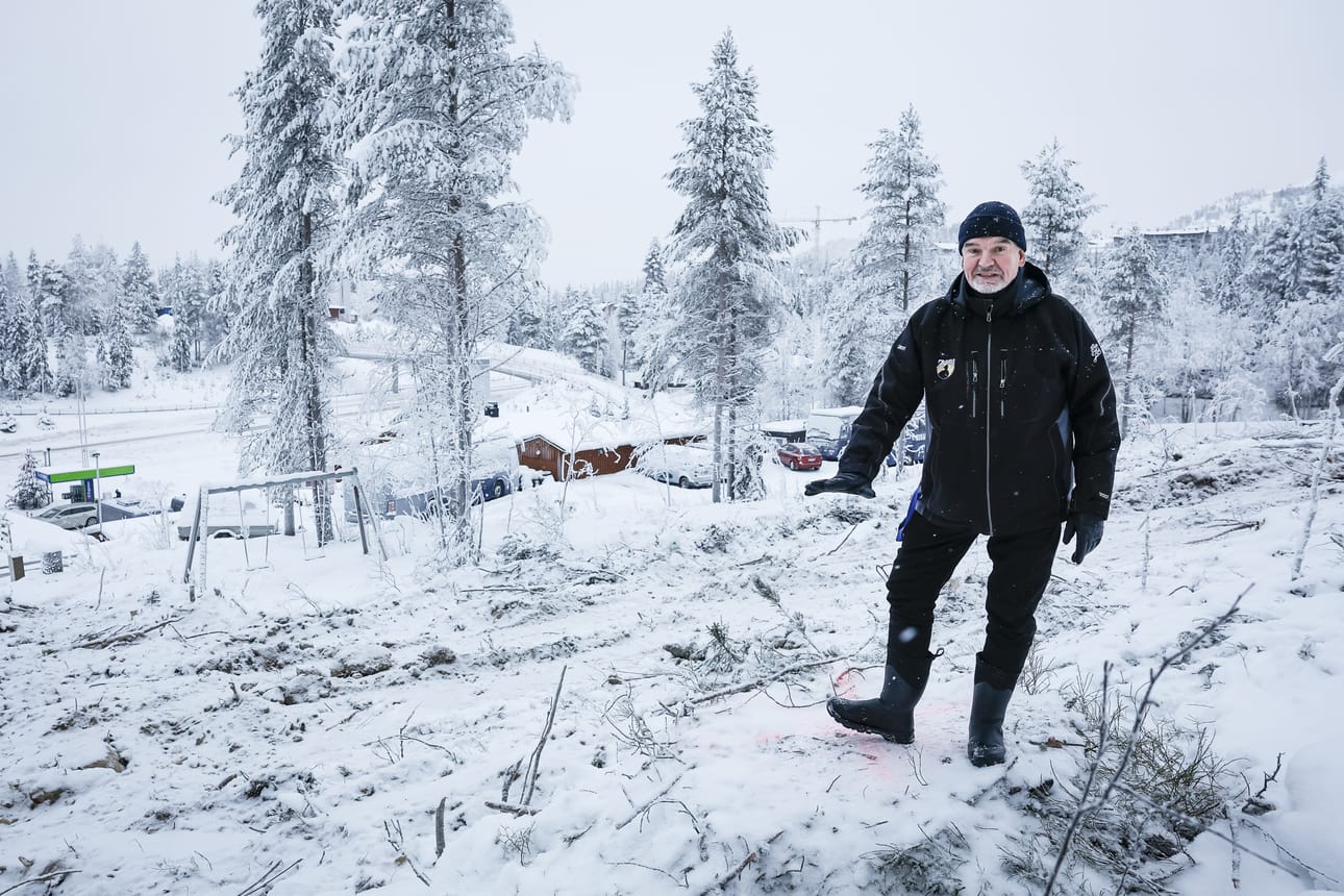 Jokke Kämäräinen kertoo, että uusien lomahuoneistojen tieltä on kaadettu puut ja kannot. Kuvassa hän näyttää, että tälle korkeudelle rinteeseen tulevat ylimmäisten asuntojen lattiat.