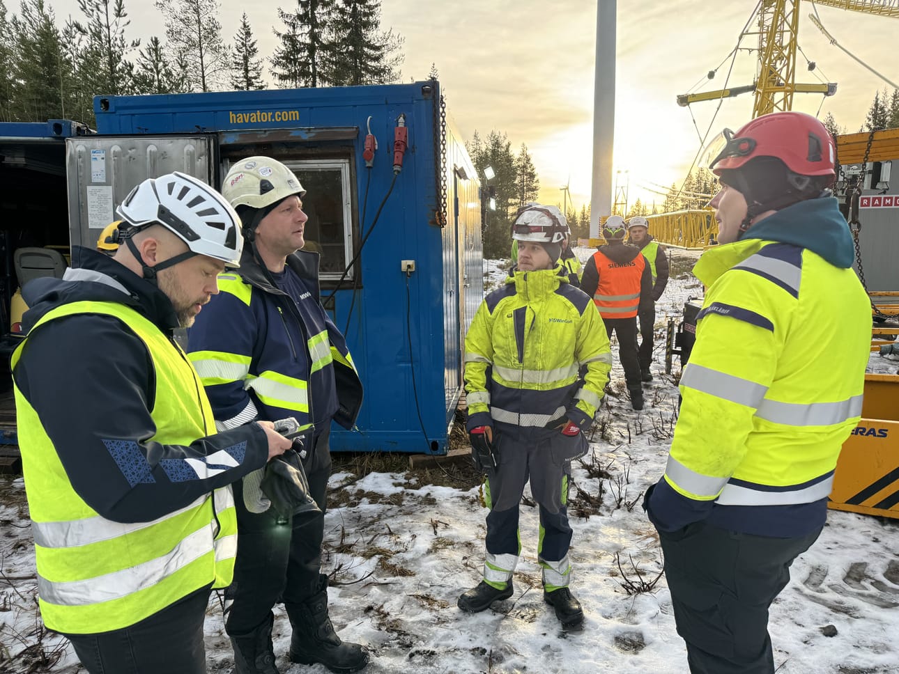 Tuulivoimaloiden huolto ja korjaus tapahtuu monen ammattilaisen yhteystyön tuloksena. Kuvassa Merijräven Ristivedon tuulivoimapuistossa Siemens Gamesan, Puhurin ja Havatorin väkeä tilanteessa, jossa valmistaudutaan laskemaan Valtteri-voimalan siipi maan tasalle joulukuussa 2024.