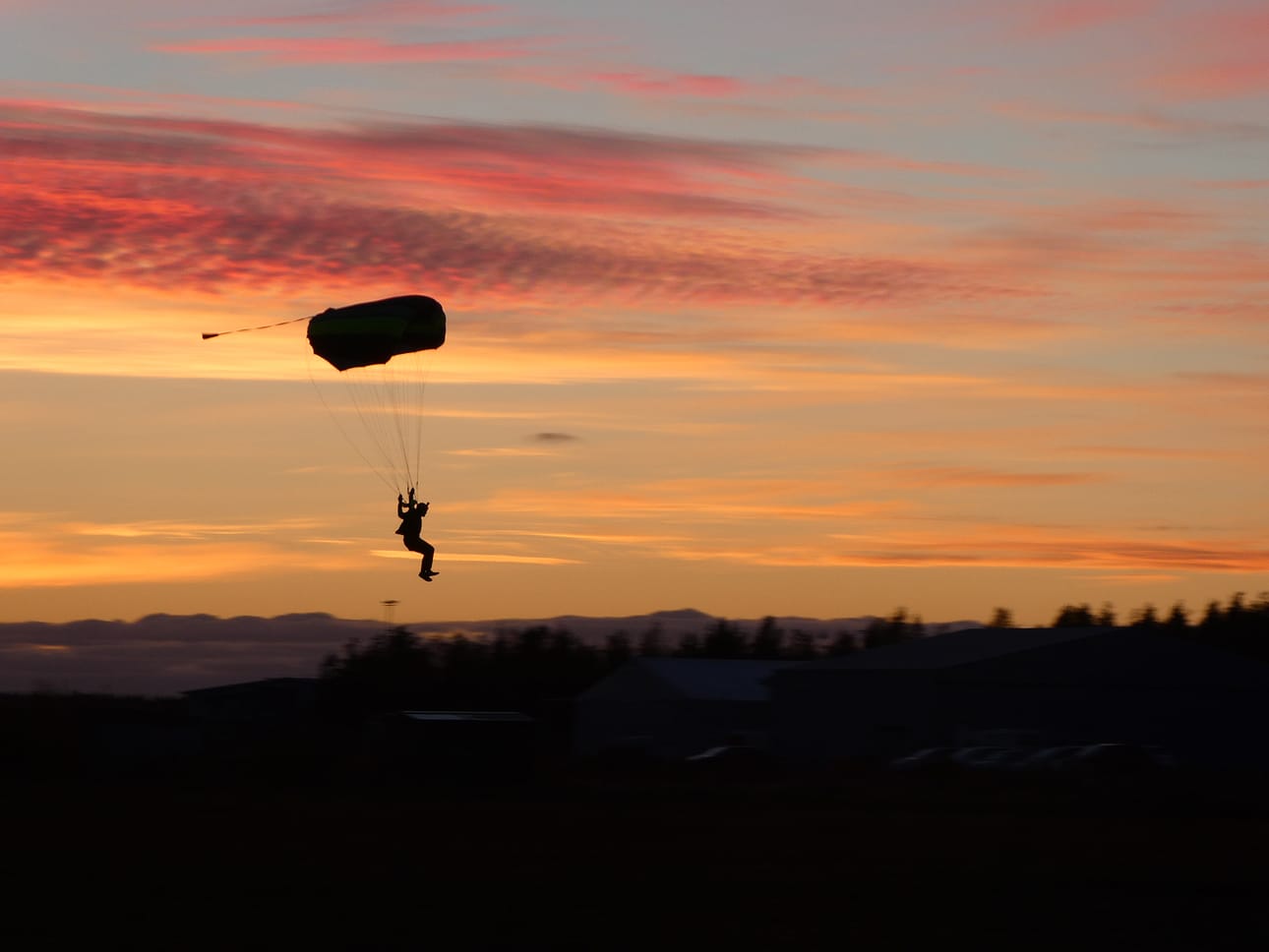 Raimo Karhu harrastaa laskuvarjohyppäämisen lisäksi valokuvaamista. Laskuvarjohyppääjän siluetti auringonlaskussa on yksi tuhansista Karhun ikuistamista laskuvarjohyppykuvista.