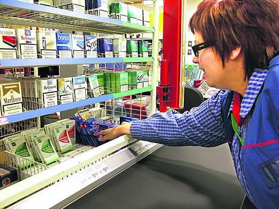 Kuusamon K-marketin kauppias Jaana Pikkarainen asettelee nikotiinipurkkaa hyllyihin. Hän kertoo, että purkkaa ostetaan nikotiinivalmisteista eniten.