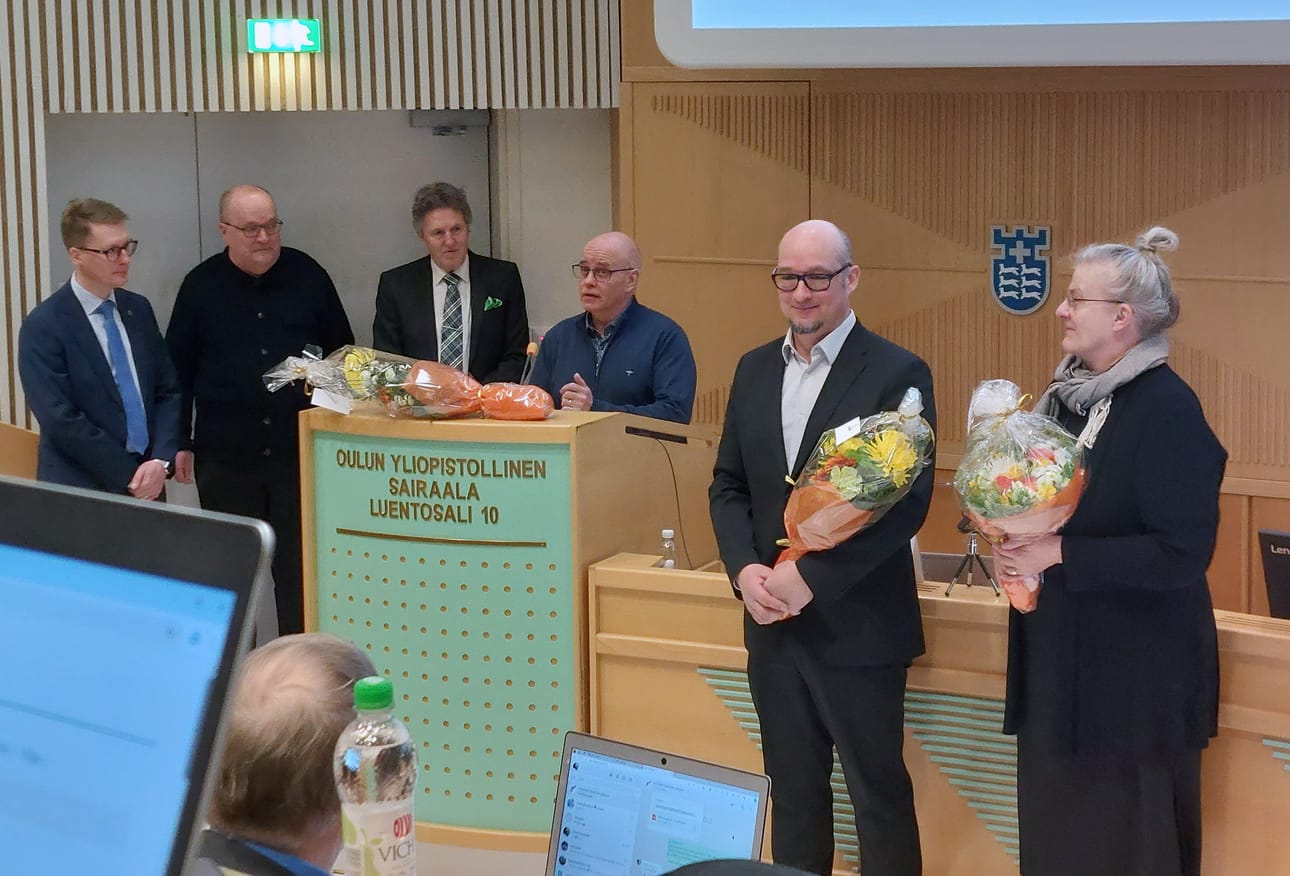 Aluevaltuusto muisti kolmea merkkipäiväänsä viettävää aluevaltuutettua. Kiitospuhetta pitämässä Jarmo Haapaniemi ja keskellä kuvassa Pekka Poukkula ja Pirkko Mattila. Onnittelijoina vasemmalla hyvinvointialueen johtaja Ilkka Luoma, aluehallituksen pj. Tapani Tölli ja aluevaltuuston pj. Kai Pajala.