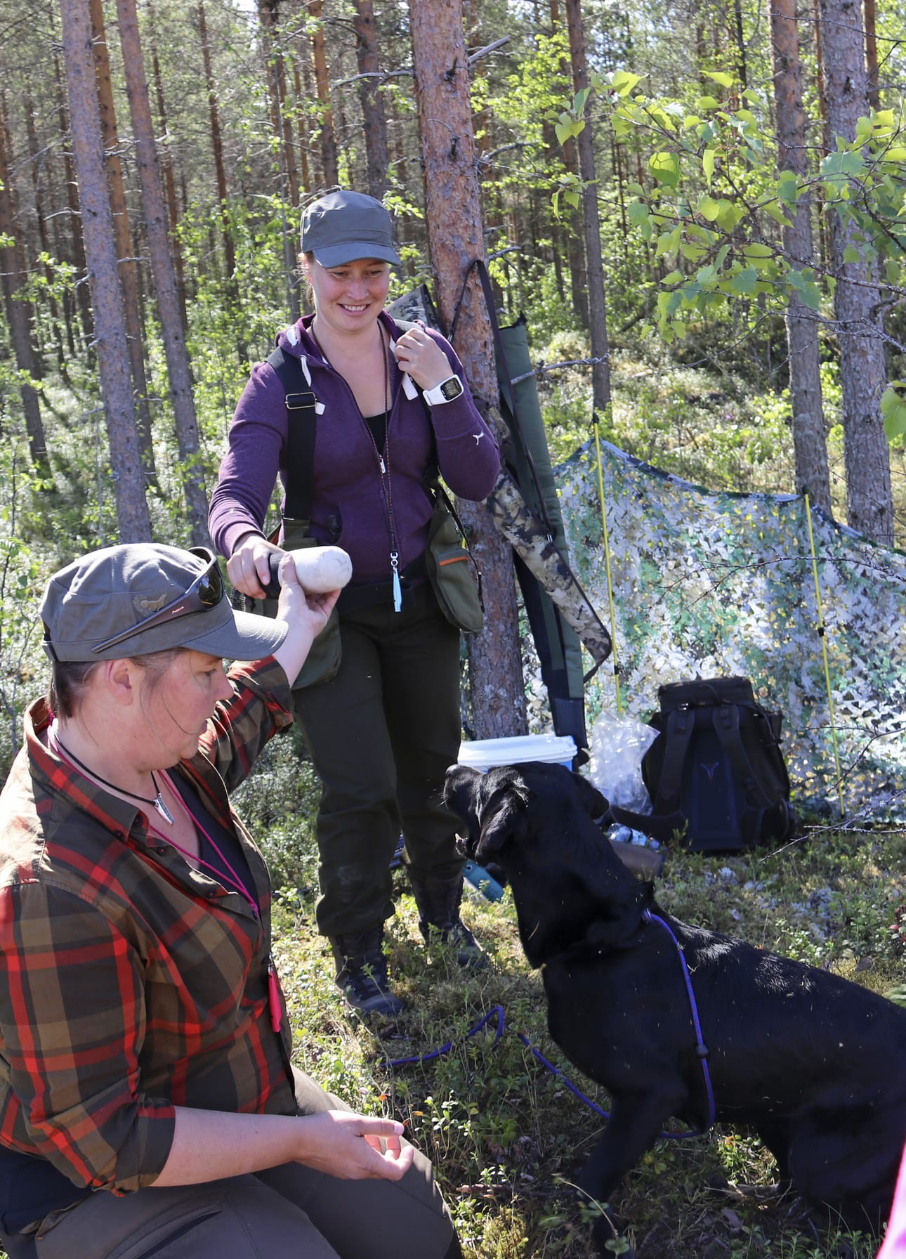 Johanna Pietikäinen (vasemmalla) ja Merja Salovaara näyttivät, miten noutaja toimii metsällä. Paukku-koira totteli käskyjä kuuliaisesti.