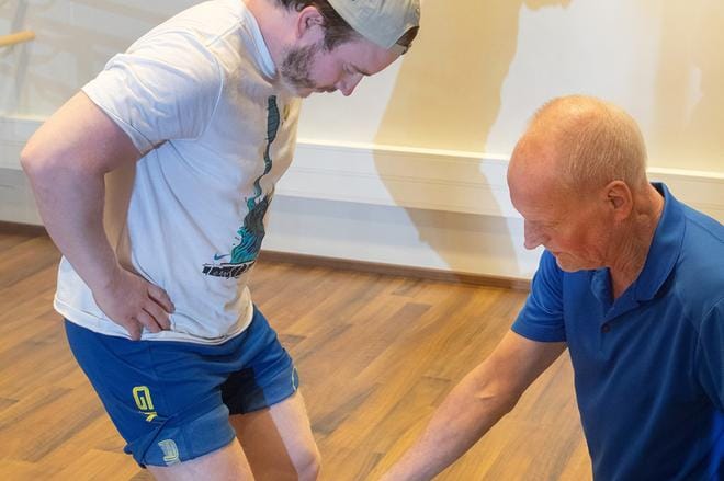 Jari-Pekka Keurulainen näyttää, kuinka polvien linjaukset tarkistetaan. Art fysion fysioterapeutti Joel Kinnunen esittelee, kuinka harjoitusliikkeet tehdään oikein.